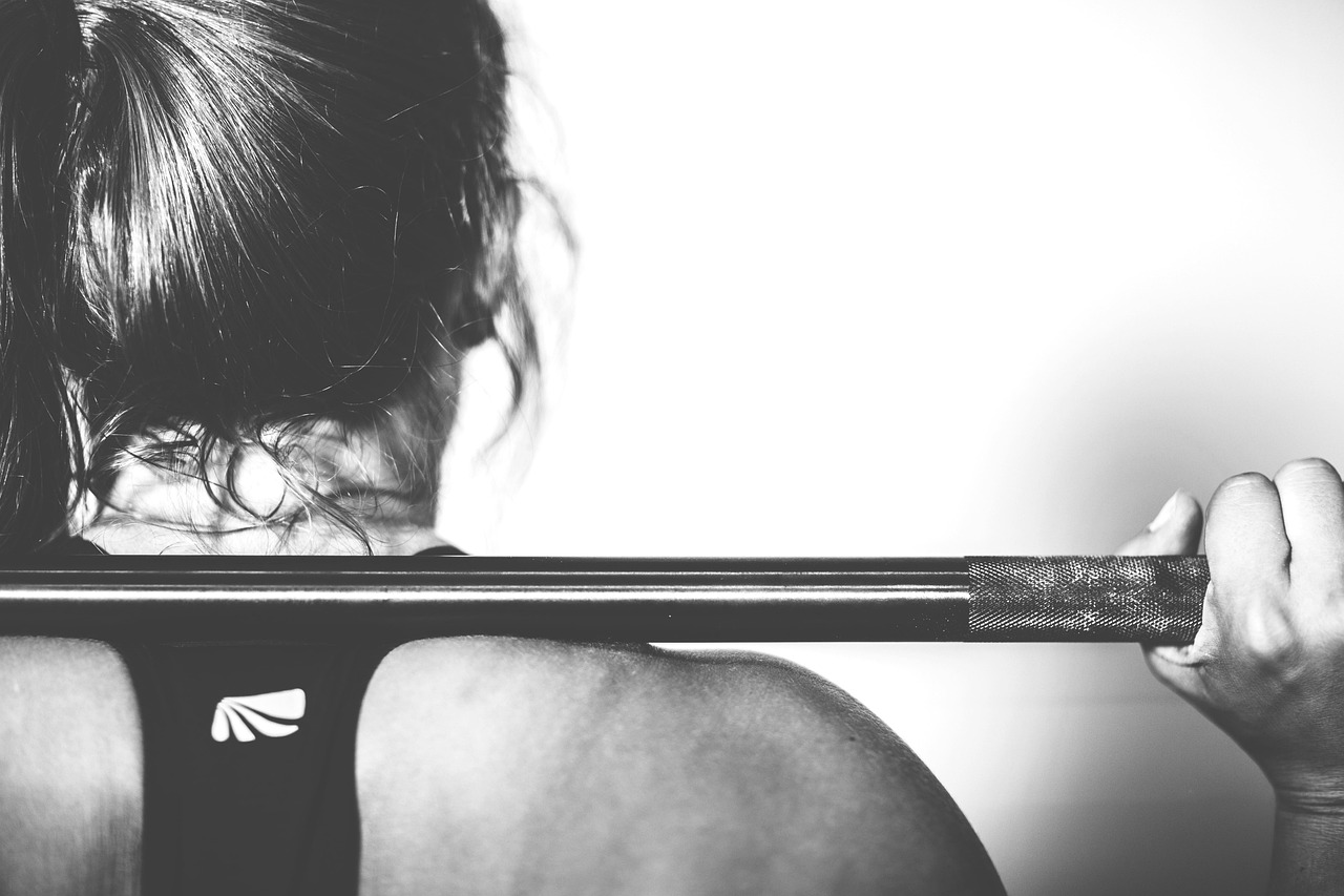 Persona madura entrenando con mancuernas en gimnasio